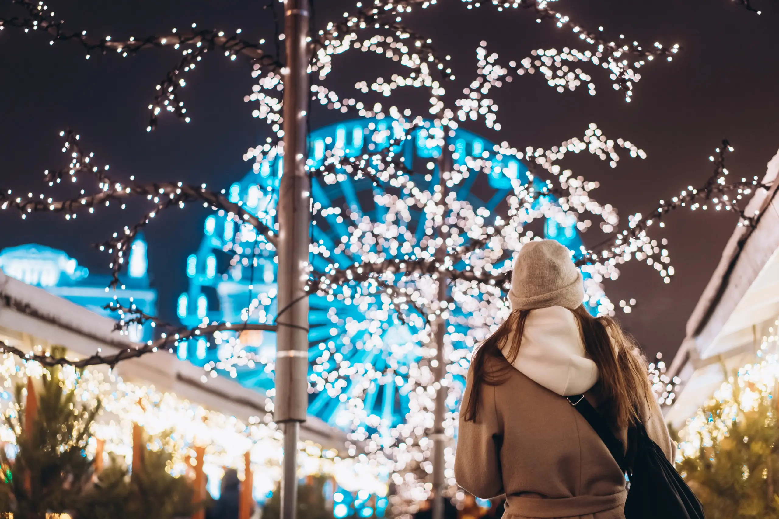 chica paseando en ciudad iluminada de navidad